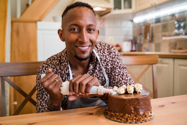 istock Brazilian man decorating a cake at home 1199831341