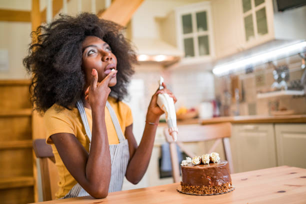 istock Afro women decorating a cake at home 1199831343