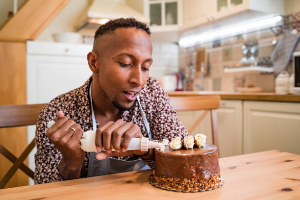 istock Brazilian man decorating a cake at home 1199831345