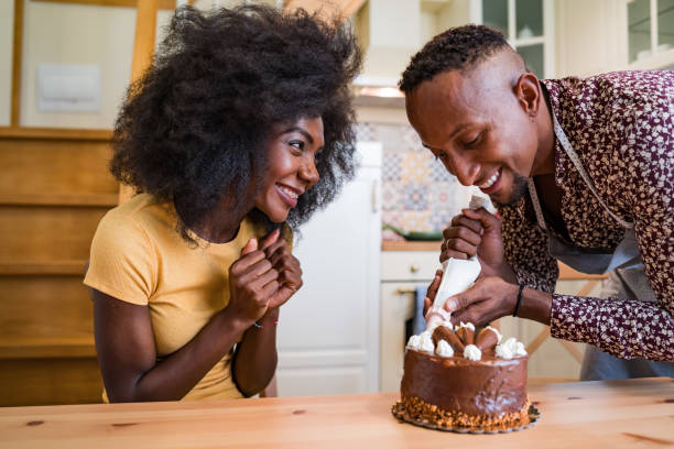 istock Couple in love decorating a cake at home 1199831346