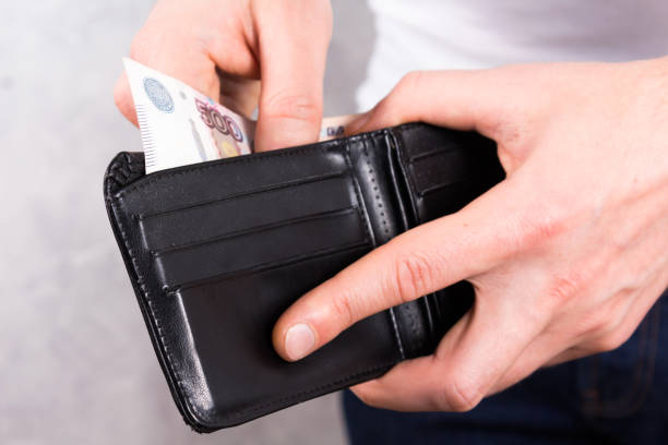 istock Young man gets cash from leather wallet. 1199832047
