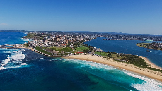 wide angle aerial drone shot of nobbys head and newcastle, australia