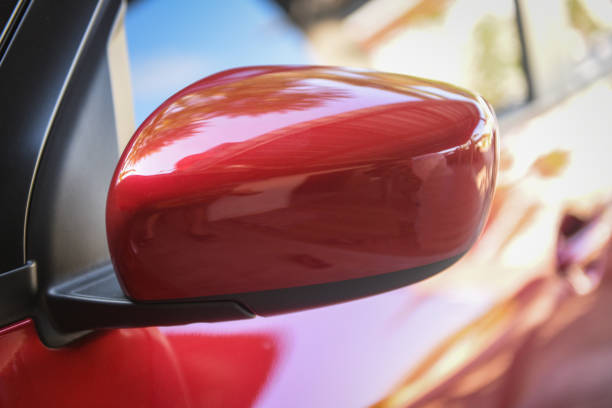 istock Red car with side rear view mirror on a modern car side mirror front  / 1199833077