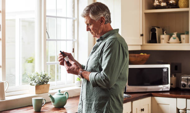 Don't take too much Cropped shot of a relaxed senior man preparing a cup of tea with CBD oil inside of it at home during the day thc photos stock pictures, royalty-free photos & images