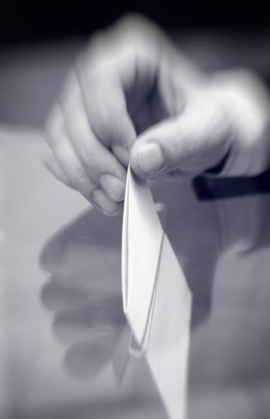 istock Image of a ballot box and hand putting a blank ballot inside 1199838729