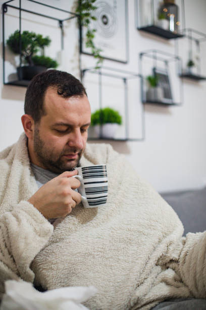 istock Sick man drinking hot tea at home 1199839389