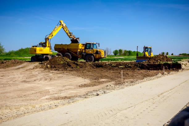 istock Excavator is loading a truck with ground on building site 1199842133