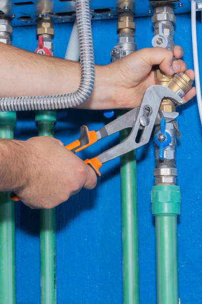 istock Plumber attaches to pipe gas boiler using adjustable wrench. 1199842539
