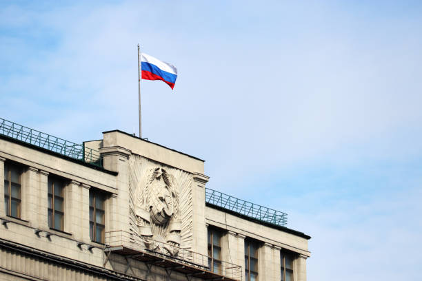 Russian flag on the parliament building in Moscow on background of blue sky and white clouds stock photo