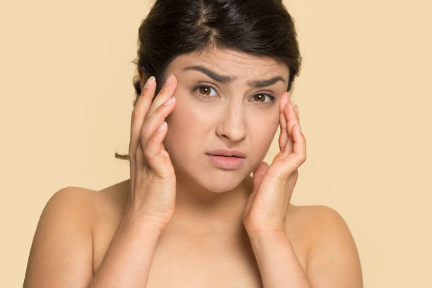 istock Frowning young indian ethnicity woman examining wrinkles. 1199847430