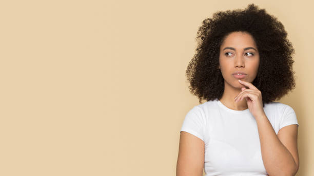 istock Pensive thoughtful doubtful young african american lady touching chin. 1199848699