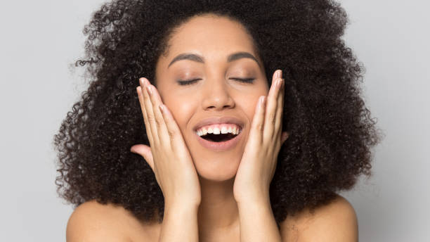 istock Smiling african american woman touching smooth cheeks. 1199848785