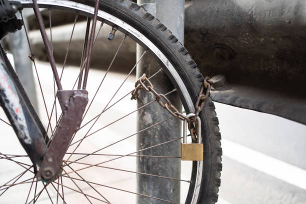 ein fahrrad mit kette und pfahl auf demfuß - rusty city life metal rust stock-fotos und bilder