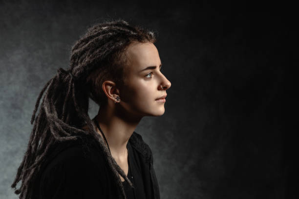 retrato de una joven con estilo con rastas sobre fondo oscuro - bizarre women portrait pierced fotografías e imágenes de stock