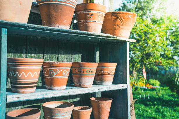 istock Vintage clay pots with ornamental pattern standing in rows on shelves 1199849075