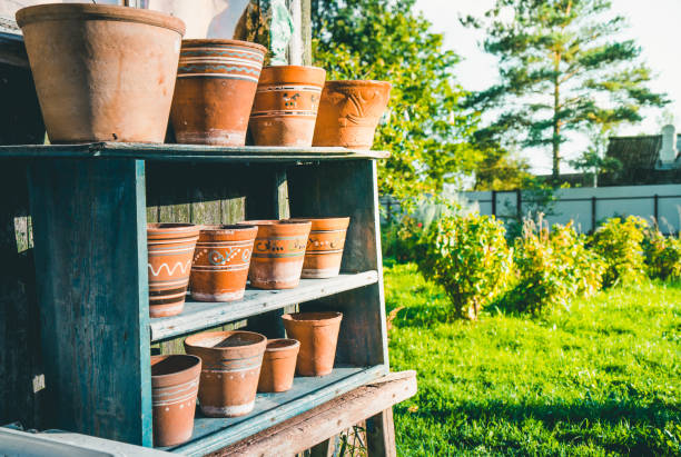 istock Vintage clay pots with ornamental pattern standing in rows on shelves 1199849101