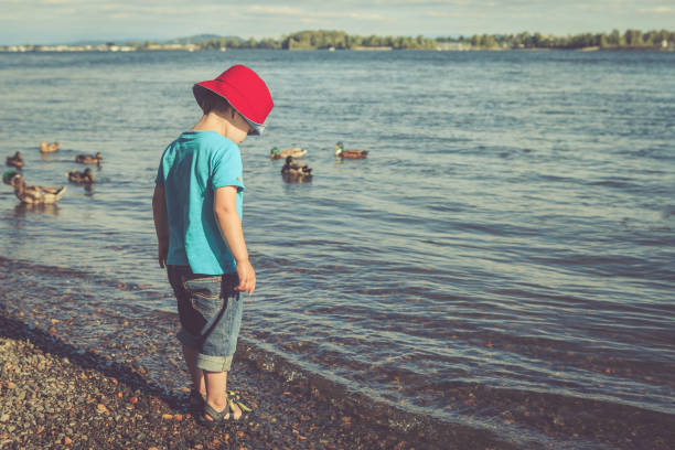 istock Little boy on the river beach in the afternoon 1199849389