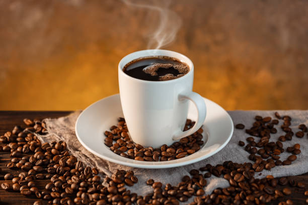 istock White coffee cup and coffee beans on wooden background 1199850055