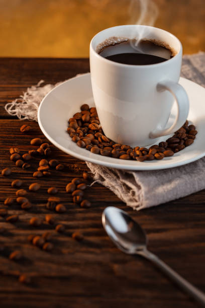 istock White coffee cup and coffee beans on wooden background 1199850131