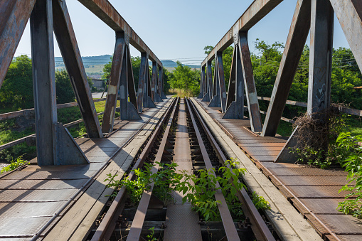 ODORHEIU SECUIESC, ROMANIA - July 2, 2019: Straight view over massive bridge with steel support on each side. Railways tracks. Symbol / concept for connection, communication, direct, peace, consequence