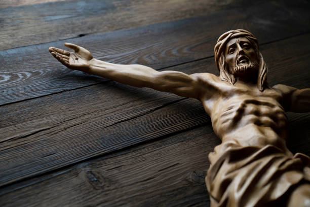 Religion theme - Jesus Christ. Cruciefied Jesus figure isolated on rustic dark brown table. liturgy photos stock pictures, royalty-free photos & images