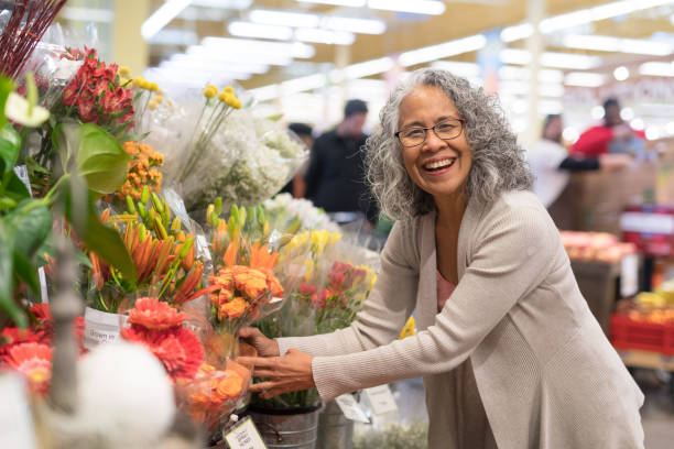 先輩女性が店で花を摘む - florist supermarket flower bouquet ストックフォトと画像