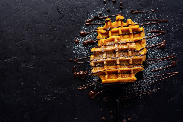 istock Pumpkin waffles with chocolate and sugar powder on dark old background. Top view 1199854764