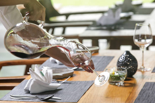 weindekanter, weingläser und rotwein. dekantieren wein sorgt dafür, dass das sediment in der flasche bleibt und sie erhalten einen schönen klaren wein und zweiten und mehr alltäglichen grund zu dekantieren ist, den wein zu beerfreuen. - wine decanter elegance pouring stock-fotos und bilder