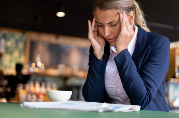 istock Business woman at a cafe having a headache 1199858232