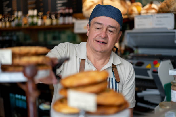 istock Happy baker selling pastries at the bakery shop 1199858258