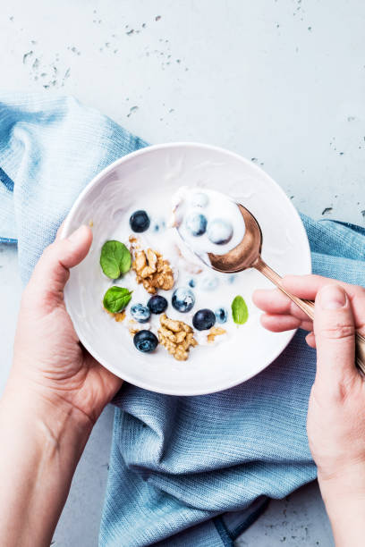 istock Hands holding a healthy breakfast bowl with yoghurt 1199861226