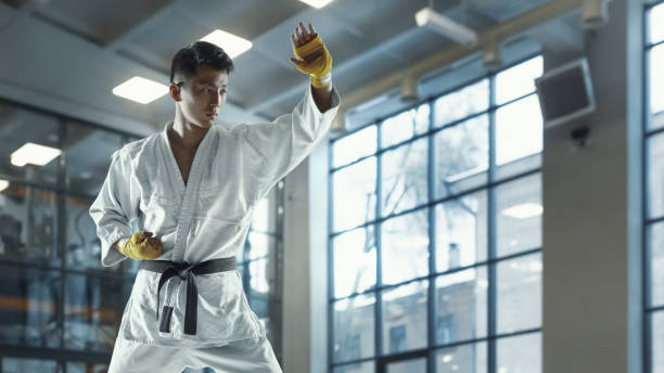 istock Confident korean man in kimono practicing hand-to-hand combat, martial arts 1199861496
