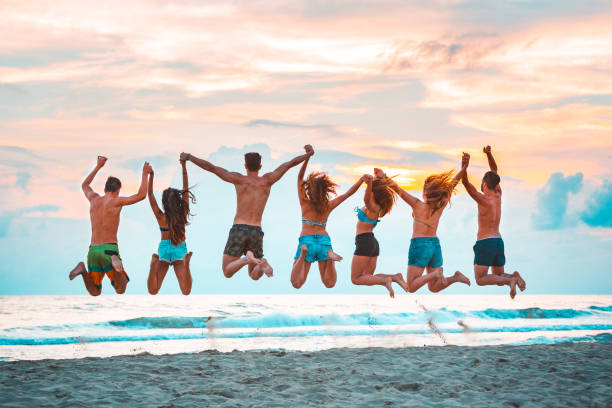Young friends jumping on the beach