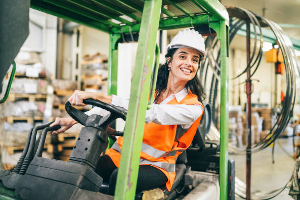 istock Female worker driving forklift in factory 1199862535