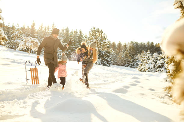 playful couple with kids in winter woods - family winter walking fun imagens e fotografias de stock