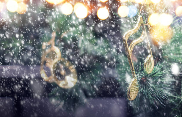 istock Music note decoration on christmas tree with snow falling in the winter 1199863237
