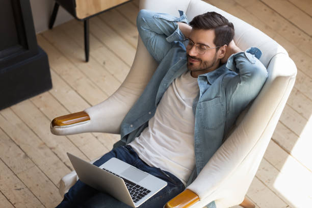istock Young freelancer relaxing on armchair, taking break during remote workday. 1199863537