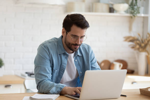 istock Head shot young businessman working remotely with computer. 1199863538