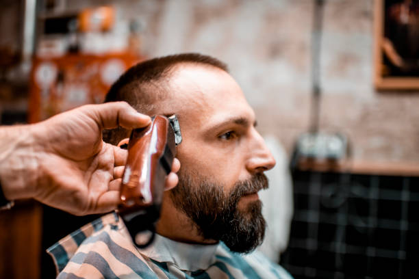 istock Making a buzz cut using an electric shaver in a barber shop 1199867068