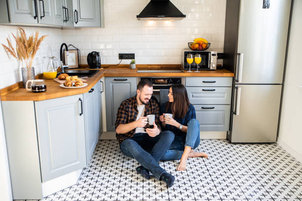 istock Happy couple sit on the floor with a cups 1199867357