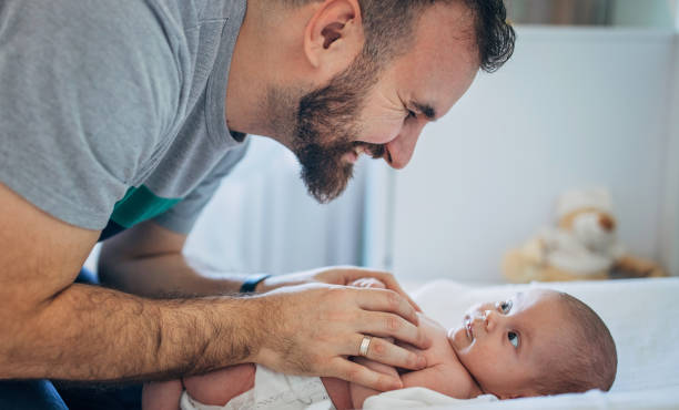 padre feliz cambiando pañal en su bebé en casa - simplicity purity joy new life fotografías e imágenes de stock