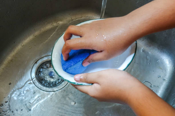 istock Hand washing a plate on a kitchen sink 1199868437