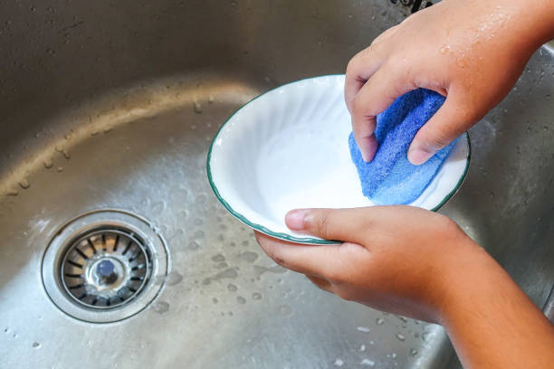 istock Hand washing a plate on a kitchen sink 1199868441