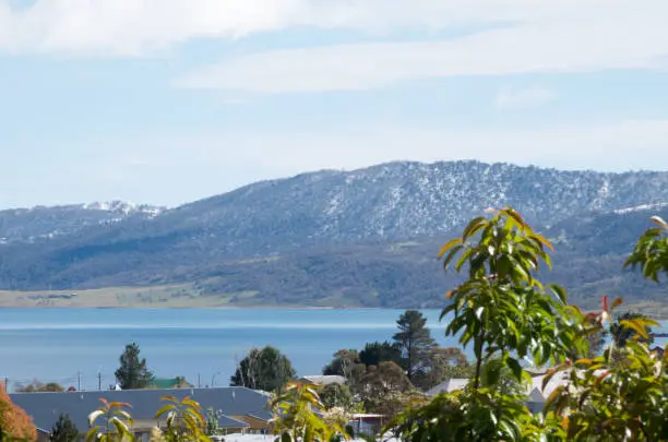 Photo of Lake Jindabyne, Jindabyne townshipand surrounding mountains covered in a dusting of snow