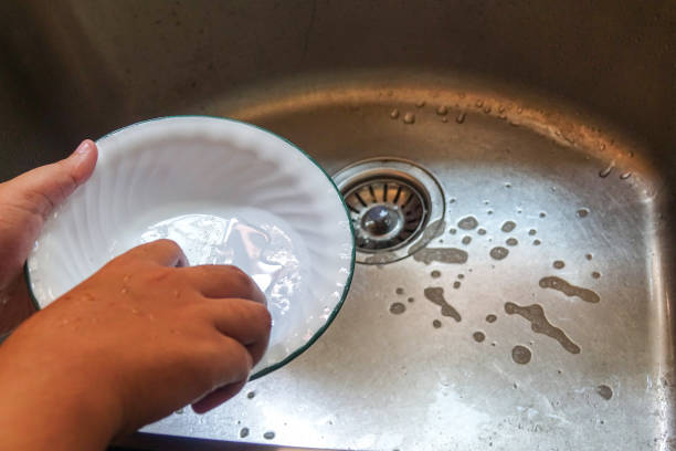 istock Hand washing a plate on a kitchen sink 1199868446