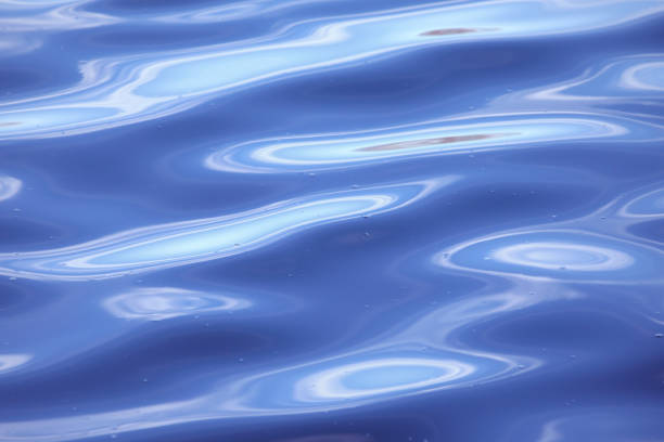 istock Abstract ripple smooth water background. Cyan blue waving water surface with light reflections. 1199869864