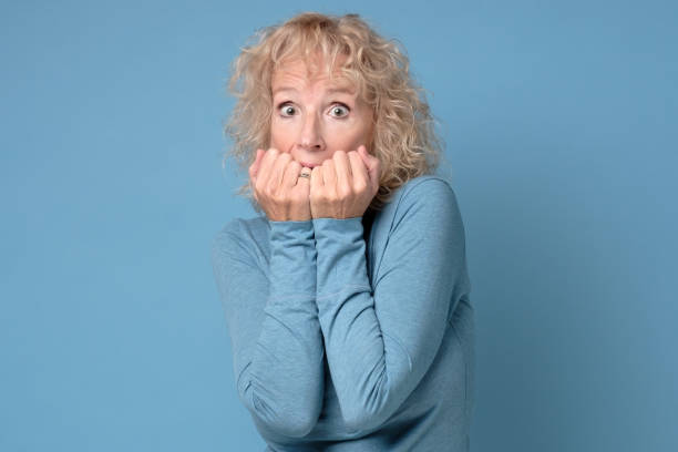 istock Nervous mature woman bites fingernails, feel anxious has scared expression 1199871620