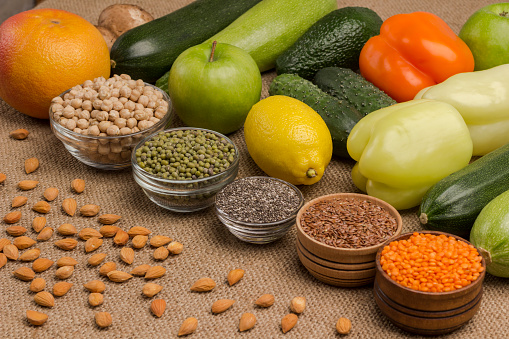Set of balanced nutrition products: chili, pepper, lemon, apple, avocado, burlap, lentils, flaxseed, chickpeas.  Natural vegetarian source of protein, calcium. Close up