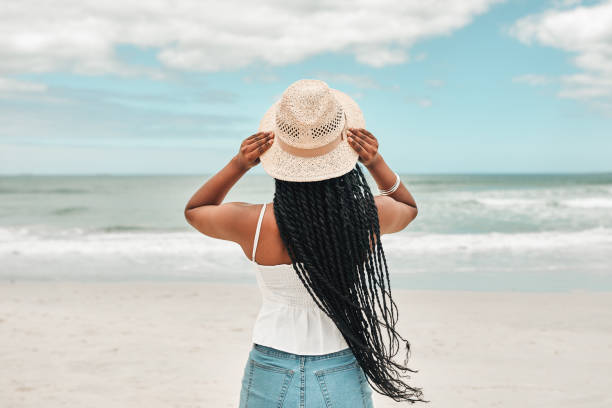 Rearview shot of a young woman spending some time at the beach