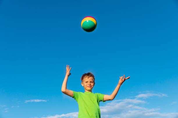 istock cute happy young boy play with ball on sky 1199875852